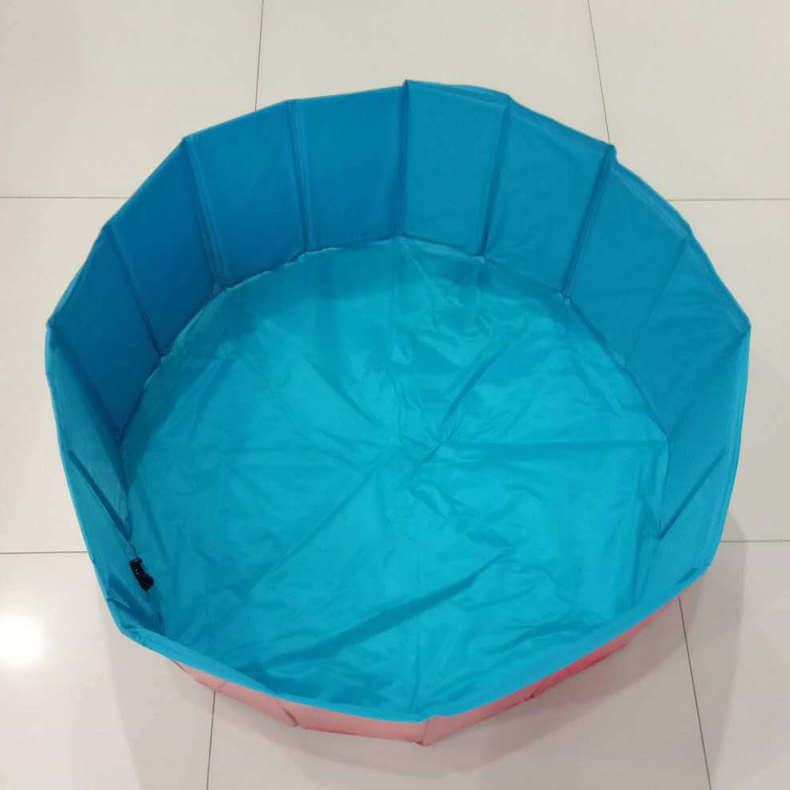 Foldable dog pool set up outdoors with a golden retriever inside