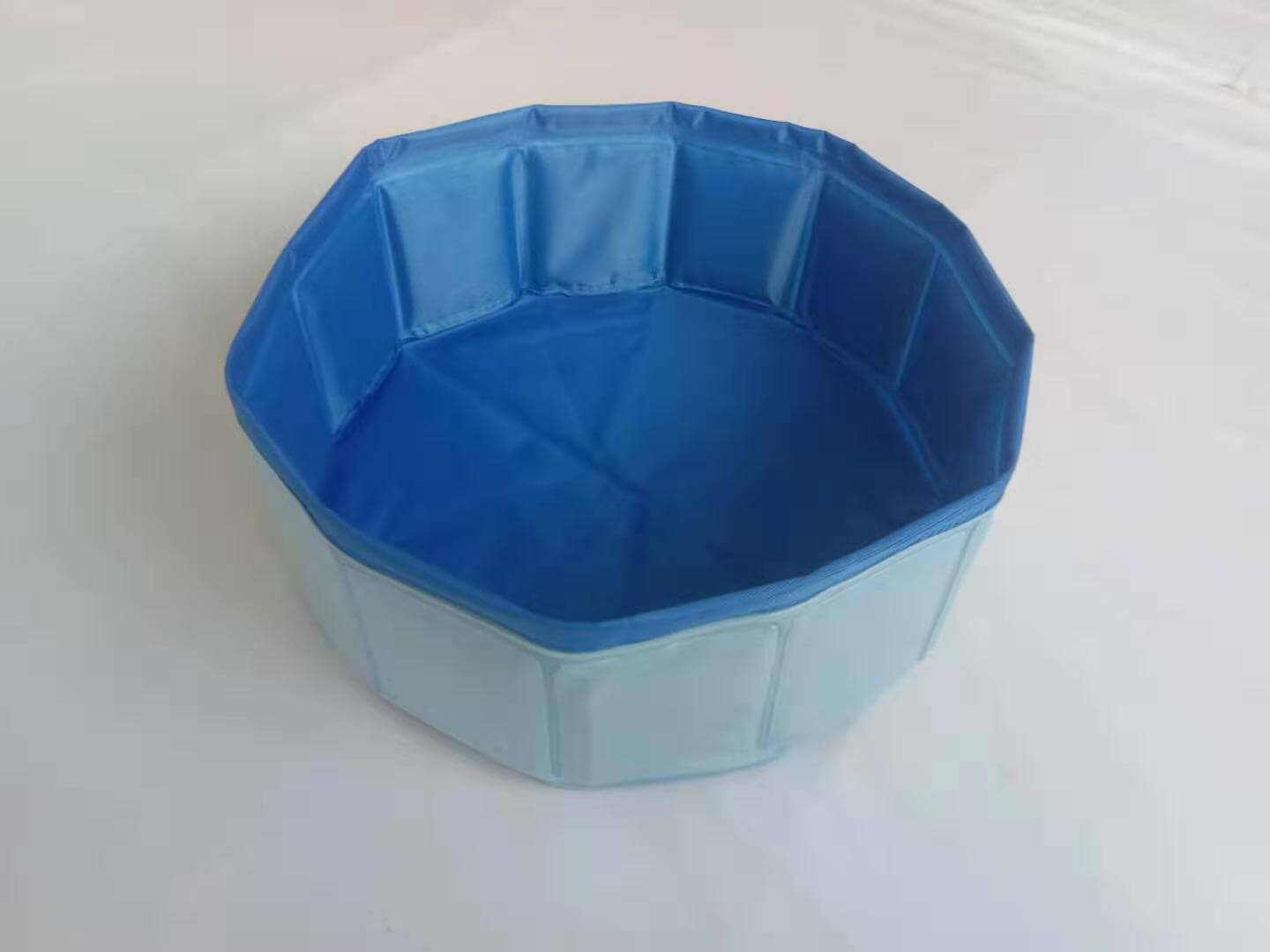Foldable dog pool set up outdoors with a golden retriever inside