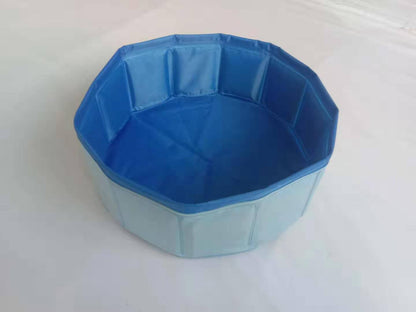 Foldable dog pool set up outdoors with a golden retriever inside